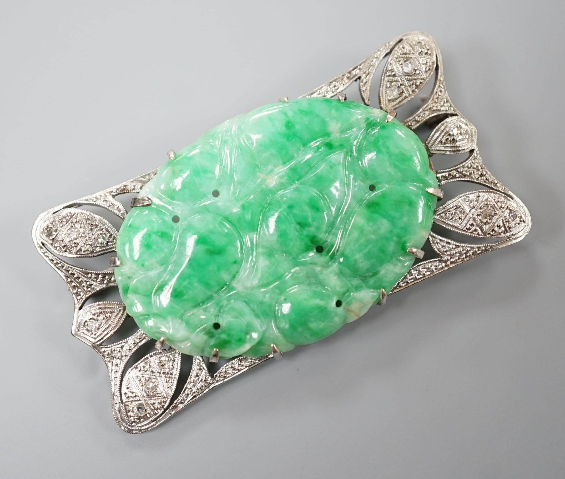 A white metal (stamped 9C?), diamond chips and oval carved jade set shaped rectangular brooch, 52mm, gross weight 13.1 grams.